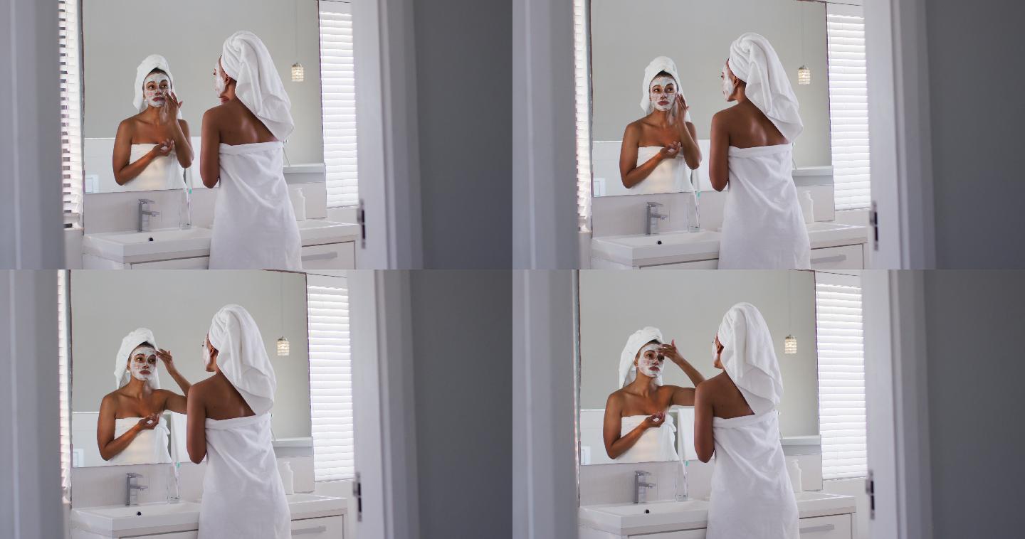非裔美国妇女在浴室对着镜子时敷面膜