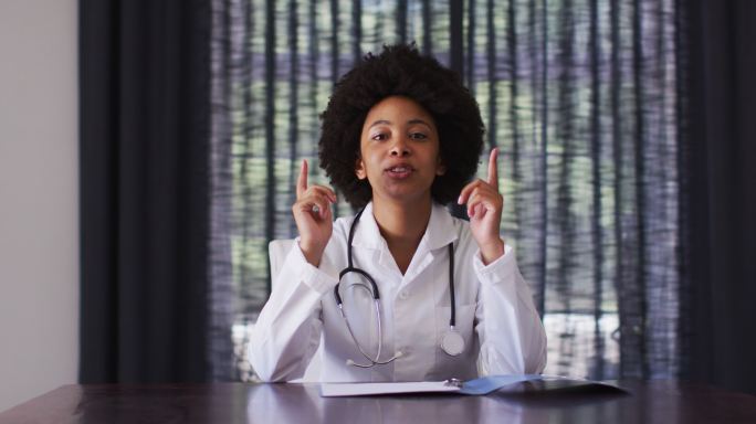 非裔美国女医生坐在家里讲视频电话