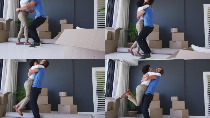 混合种族的夫妇在新公寓的纸箱之间一起跳舞