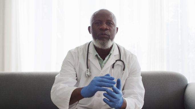 男非洲裔美国医生的肖像展示如何在视频通话时遮住你的嘴