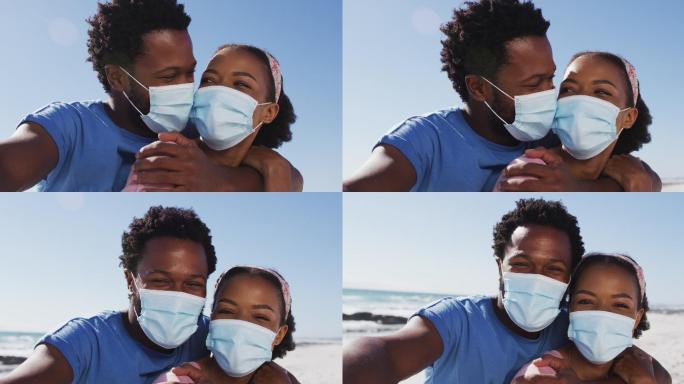 在海滩上，一对非裔美国夫妇戴着面具望着镜头