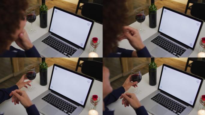 白种女人有一个浪漫的晚餐在视频聊天使用笔记本与复制空间