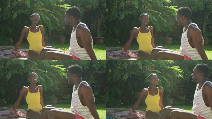 一对快乐的非裔美国人坐在阳光明媚的花园里谈笑风生