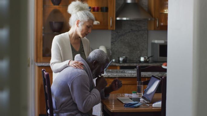 生病的混血老年夫妇正在家里的笔记本电脑上进行视频通话