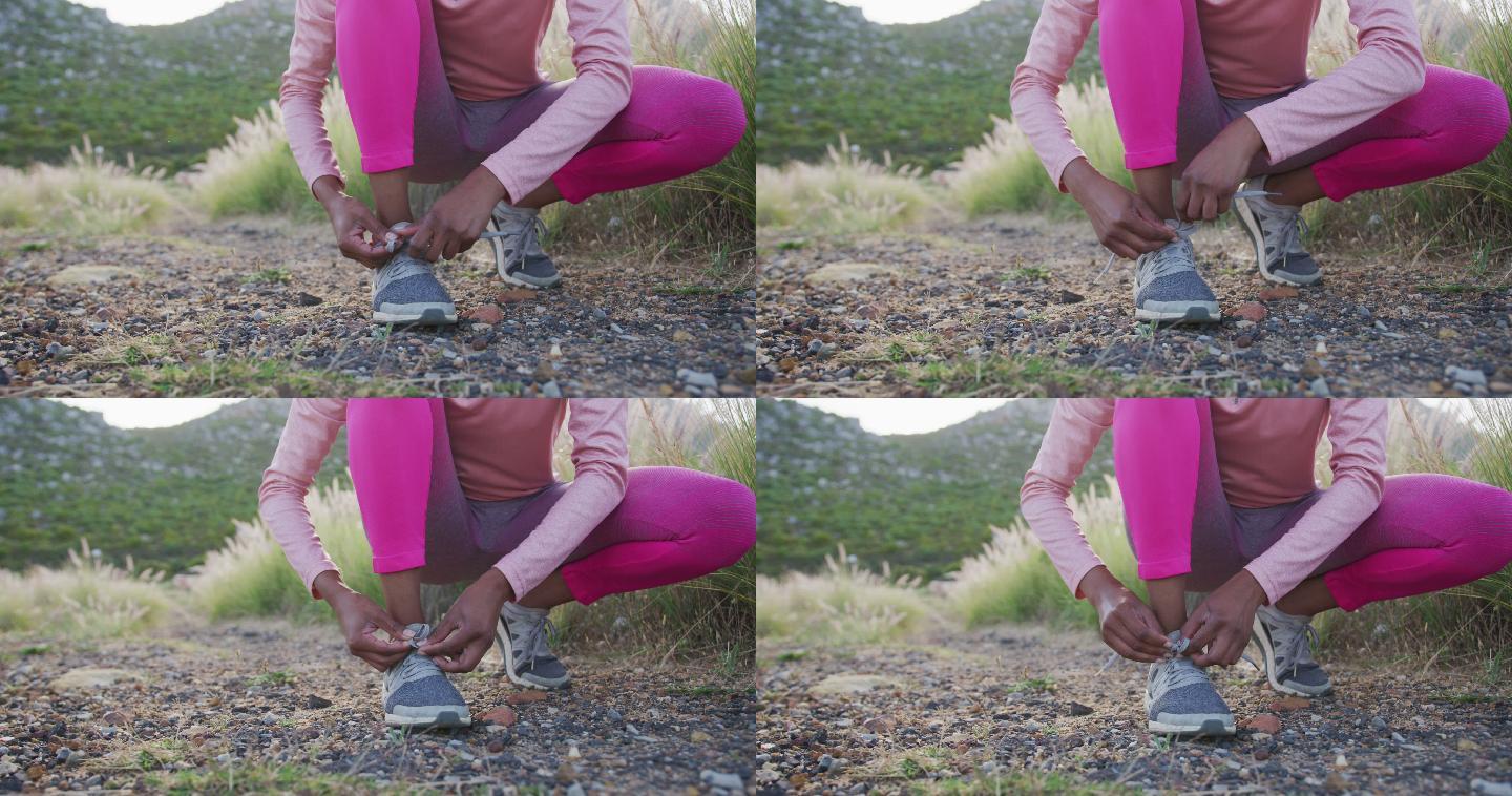 低段的混合种族妇女在农村练习系鞋带