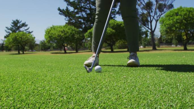 一个阳光明媚的日子，在高尔夫球场练习高尔夫的白人老年人的低部分