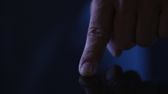 白种人男子的食指使用数字界面，将指纹应用到触摸屏上