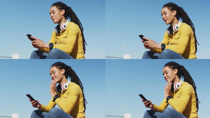 一名非裔美国妇女坐在海边散步时使用智能手机