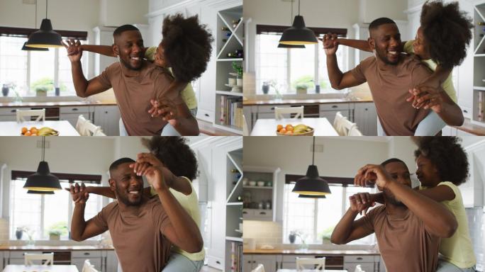 非裔美国人的女儿在厨房里抱着父亲