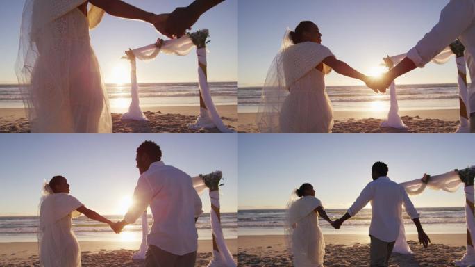 相爱的非裔美国人结婚，在日落时分的海滩上牵着手