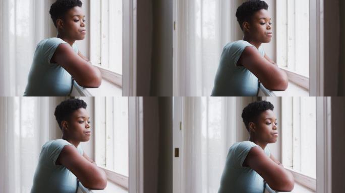 一位非裔美国妇女在家望着窗外