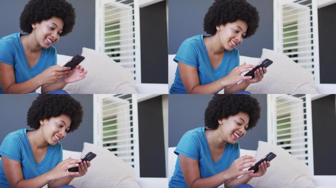 一位非裔美国女性坐在家里的沙发上使用智能手机