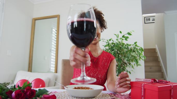 一个混血女子在情人节视频约会，喝着酒