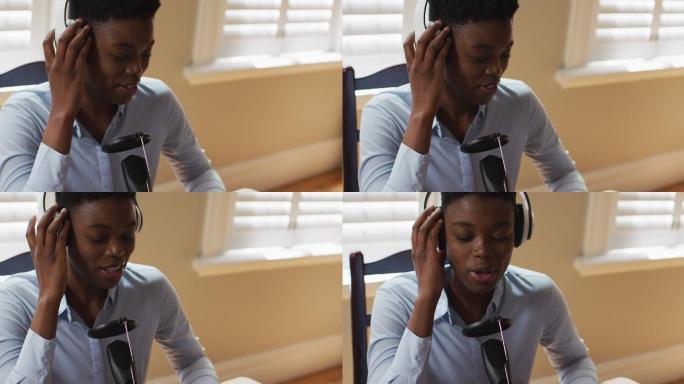 非裔美国妇女戴着耳机在家对着麦克风唱歌