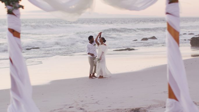相爱的非裔美国人结婚，在海滩上跳舞