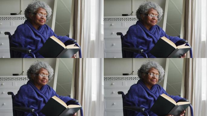 高级非洲裔美国妇女坐在轮椅上在家里看书