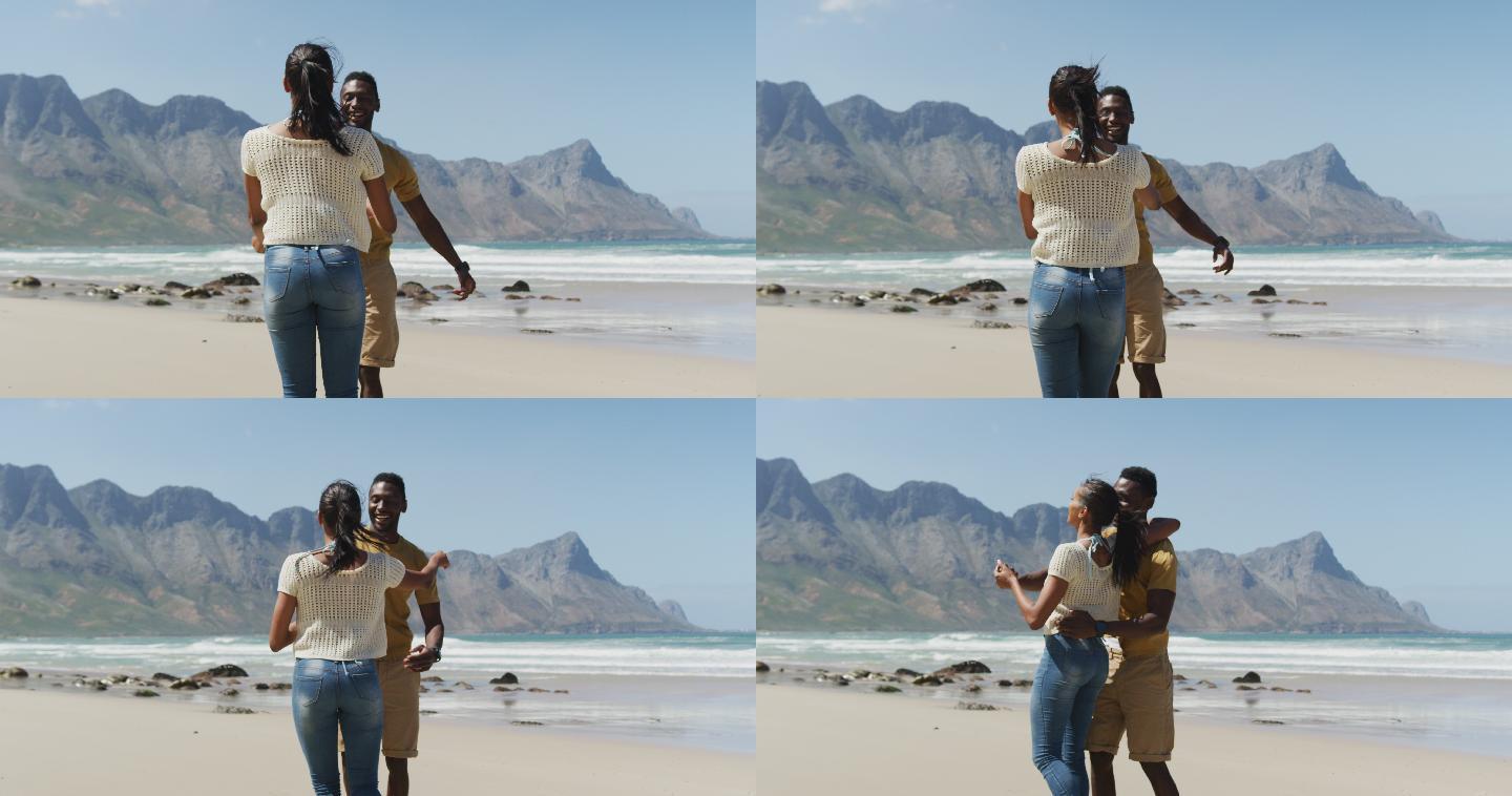 快乐的非裔美国人情侣在海滩上一起跳舞