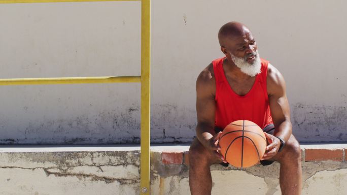 老年非洲裔美国人锻炼坐和打篮球
