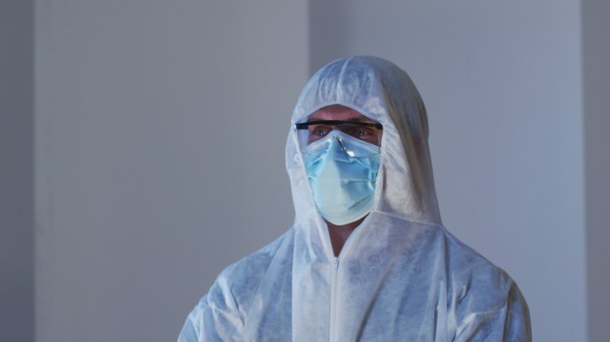 白人男性医务工作者的肖像，穿着防护服，戴着口罩和安全眼镜