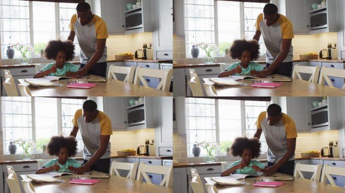 非裔美国人的女儿和她的父亲在厨房的桌子上一起做她的功课