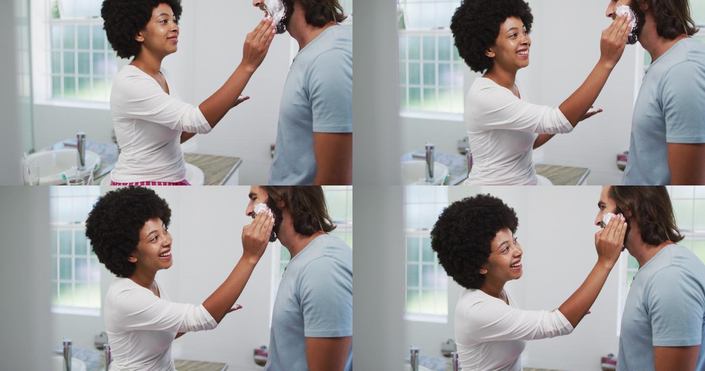 一位非裔美国妇女在家里把剃须膏涂在她丈夫脸上