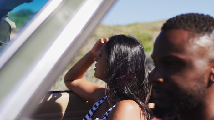 一对非洲裔美国夫妇开着敞篷车在乡间小路上行驶