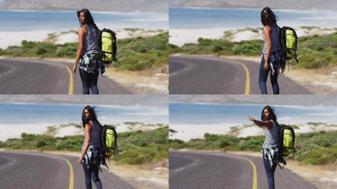 非裔美国妇女，背双肩包，试图在路上搭车