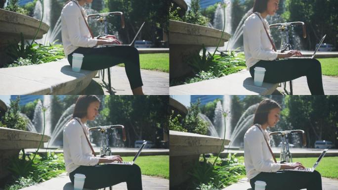 非裔美国妇女骑自行车在城市公园使用笔记本电脑