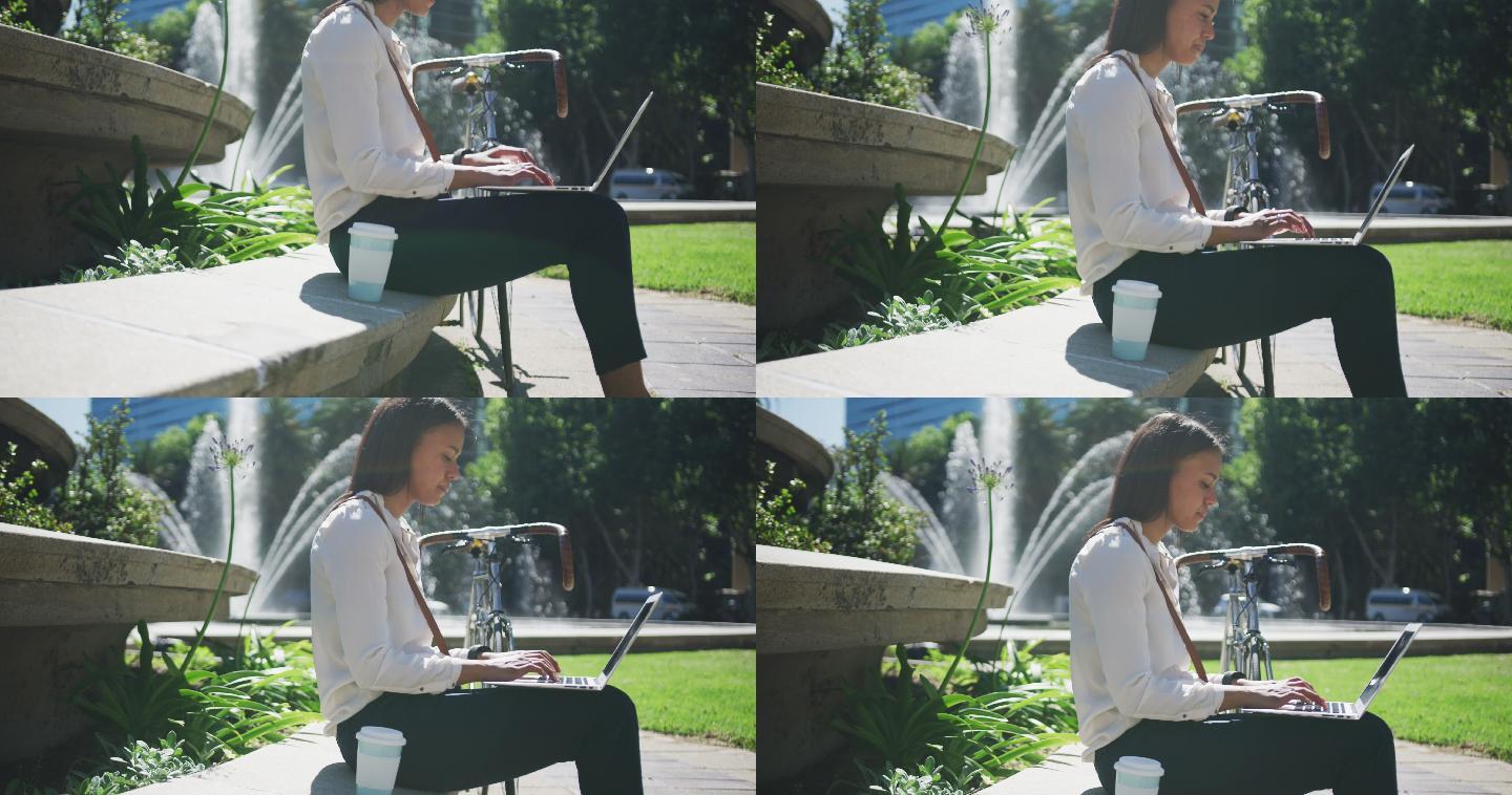 非裔美国妇女骑自行车在城市公园使用笔记本电脑
