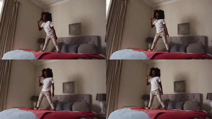 一个非裔美国女孩拿着梳子站在家里的床上唱歌