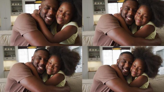 非洲裔美国人的女儿和她的父亲微笑着拥抱在沙发上