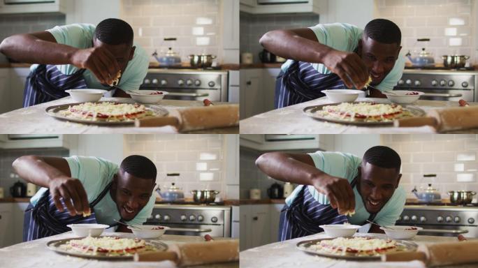 非裔美国人在厨房做披萨洒碎奶酪