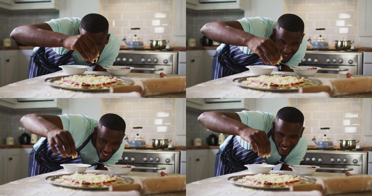 非裔美国人在厨房做披萨洒碎奶酪