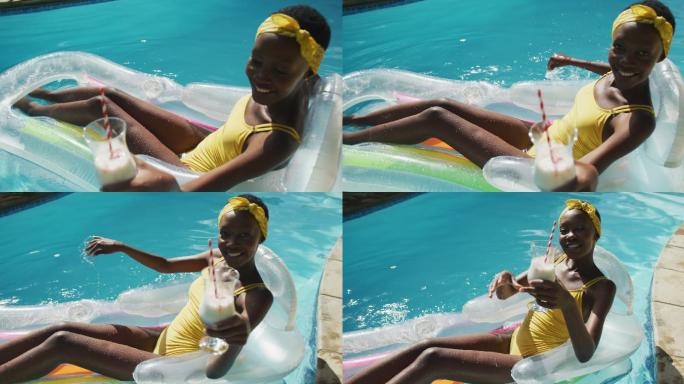 迷人的非洲裔美国女人坐在充气抱着饮料和微笑在游泳池