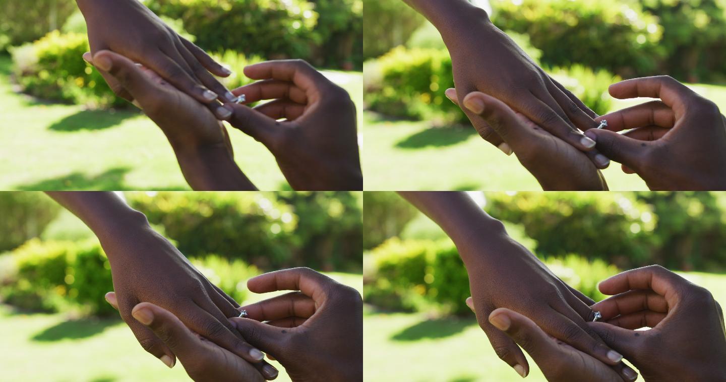 一对非洲裔美国人在阳光花园男子提议把戒指戴在她的手指上