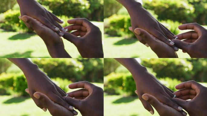 一对非洲裔美国人在阳光花园男子提议把戒指戴在她的手指上
