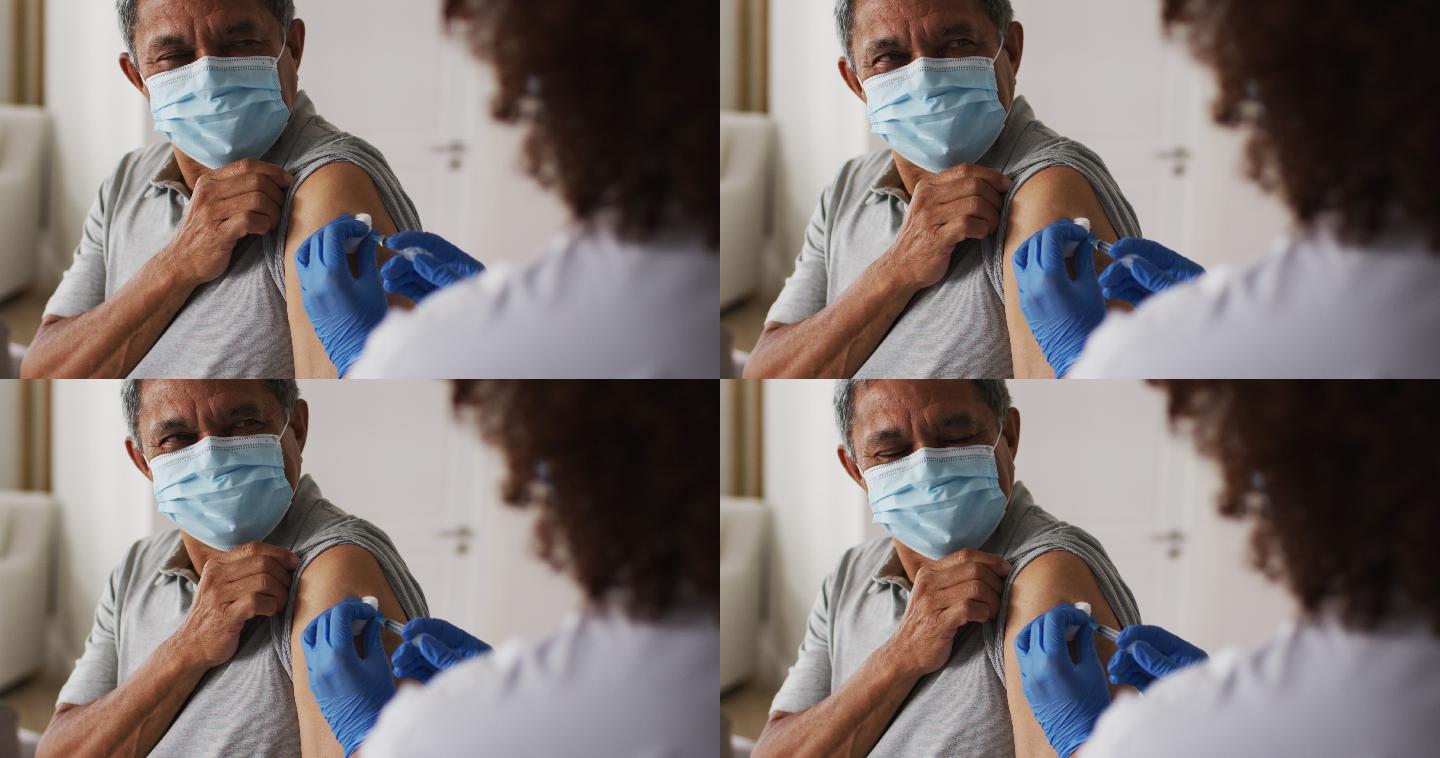 混血儿女医生戴着口罩在家给老人接种疫苗