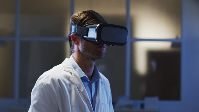 白人男医生戴着虚拟现实头盔使用虚拟界面