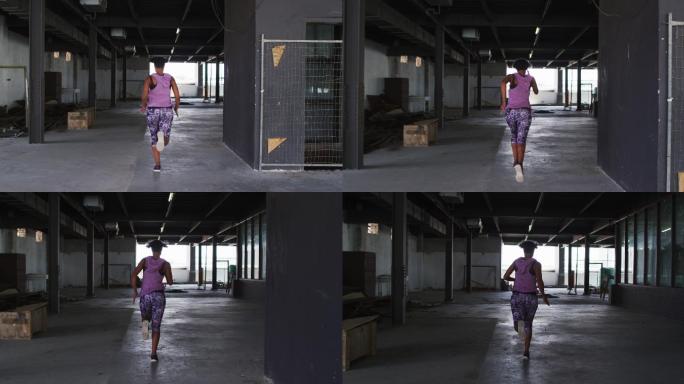一位身穿运动服的非裔美国妇女在空旷的城市建筑中慢跑