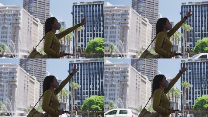 非裔美国妇女戴着口罩，拿着咖啡，举起手叫出租车