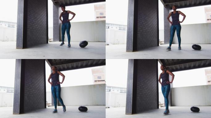 非裔美国妇女休息后运动与实心球在一个空的城市建筑