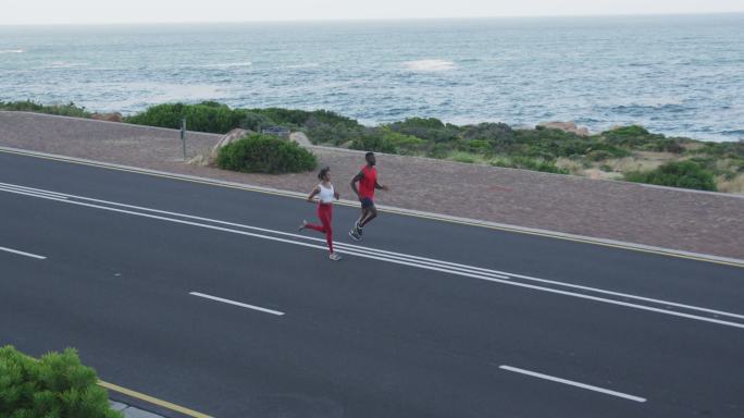 不同的健康夫妇锻炼跑步在一个山腰的乡村道路
