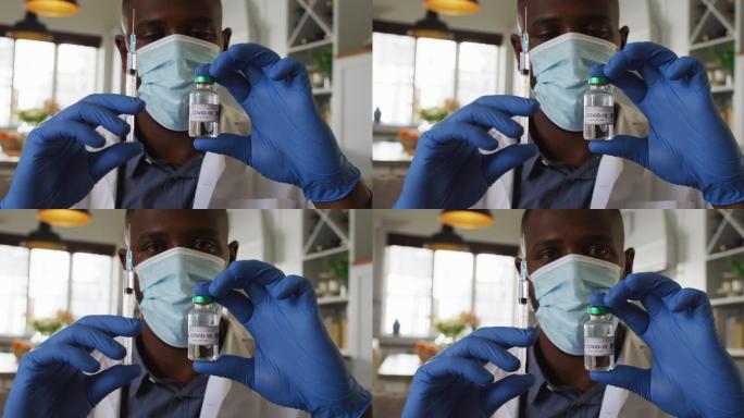 非裔美国医生戴口罩，手持covid-19疫苗和注射器