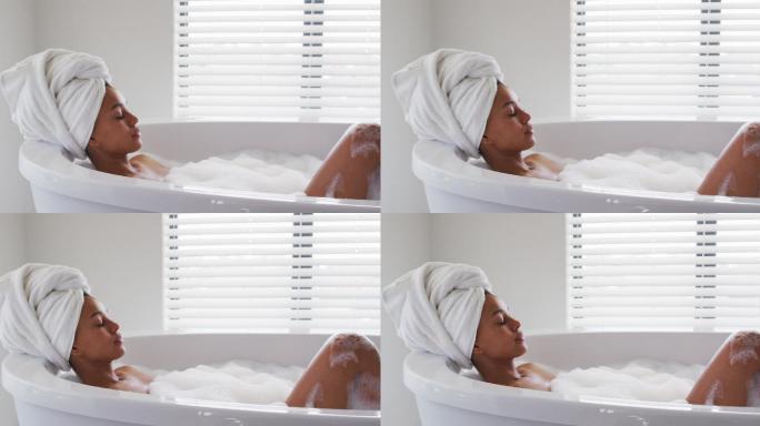 非裔美国妇女在家浴室的浴缸中放松
