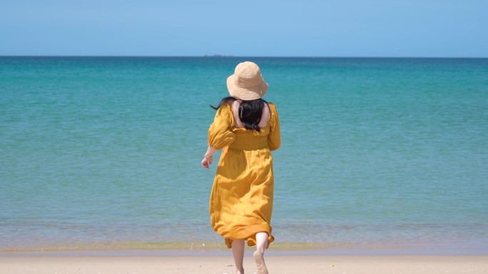 夏天的海南万宁，一个黄裙子美女跑向大海