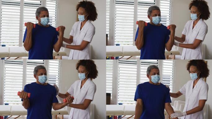 混血女性物理治疗师戴着面具帮助老年人使用哑铃锻炼