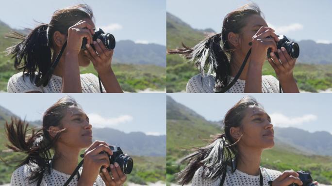 一位非洲裔美国妇女在山里徒步时用数码相机拍照