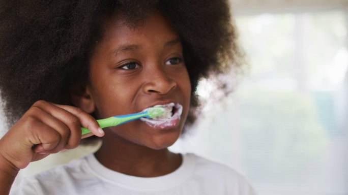 一个非裔美国女孩在浴室里刷牙
