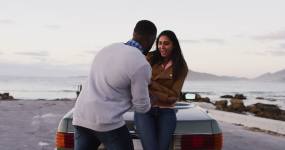 一名非洲裔美国男子在公路上敞篷车旁用戒指向女友求婚视频素材