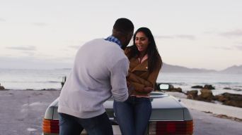 一名非洲裔美国男子在公路上敞篷车旁用戒指向女友求婚视频素材